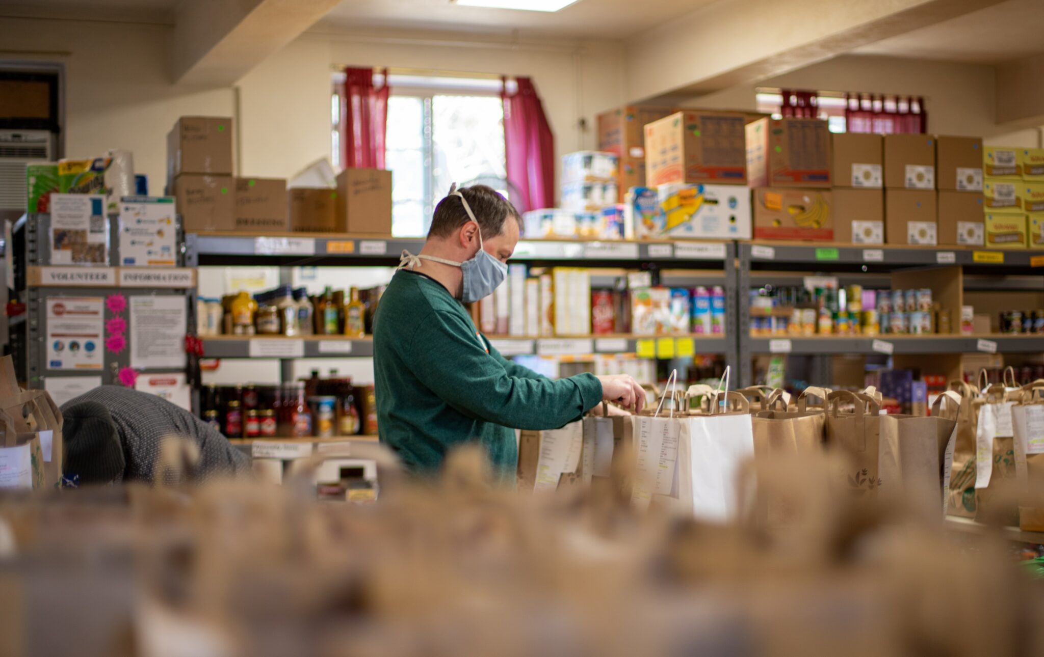 a person filling bags at a food bank for the page the better alternative to a card payment for a charity