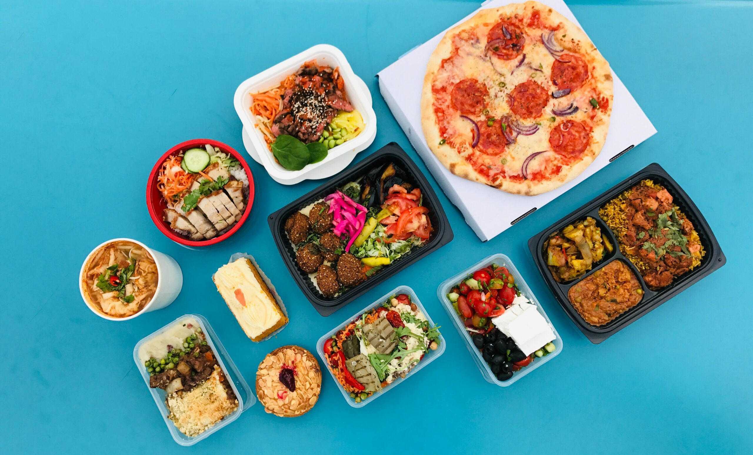 An image of various foods laid out on a blue floor for the page the better alternative to collecting card payments for a takeaway