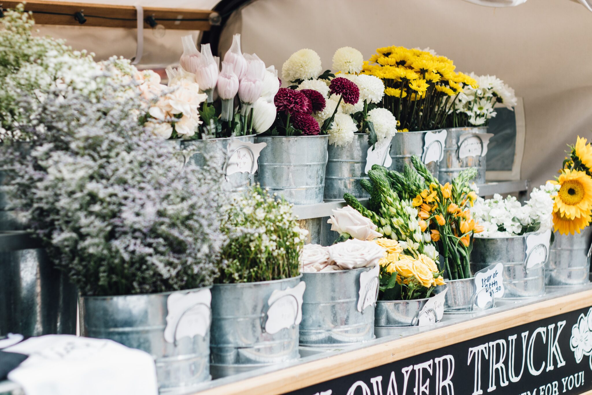 image of some flowers in tin pots for the page the better alternative to card payments for a market trader
