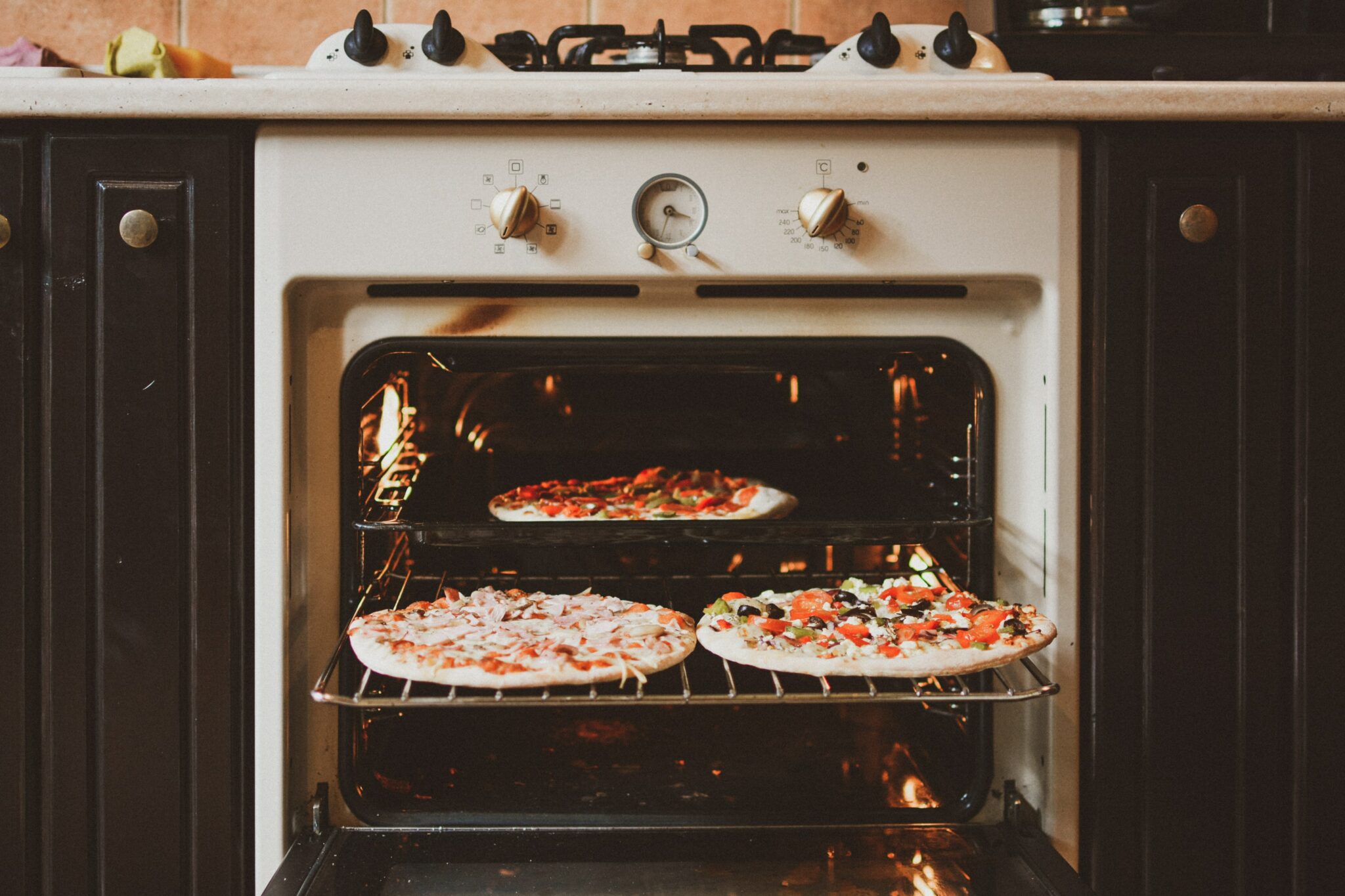 an oven with 3 different pizzas inside with the door open for the page collecting bank transfer payments as an oven cleaner
